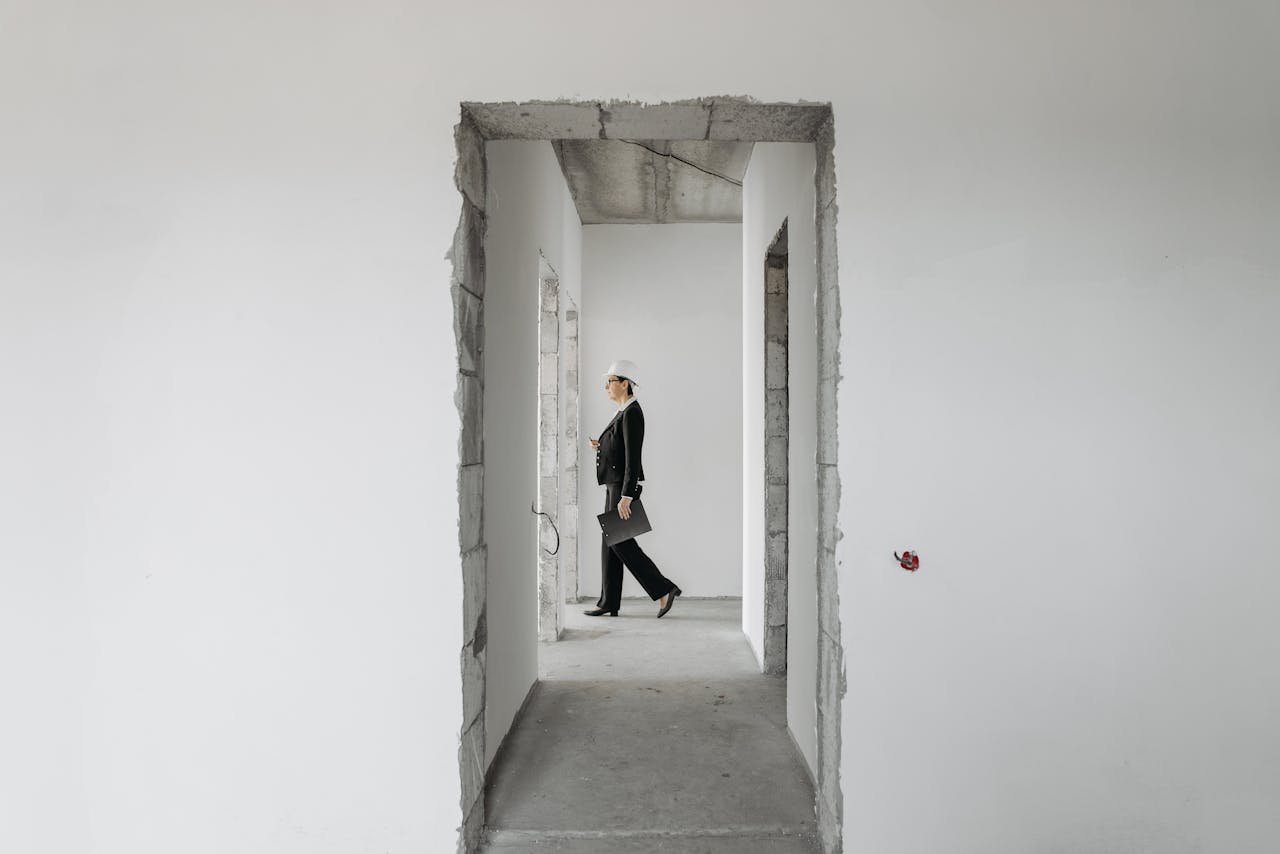 Professional woman in formal attire inspects an unfinished construction site. Ideal for real estate and construction themes.